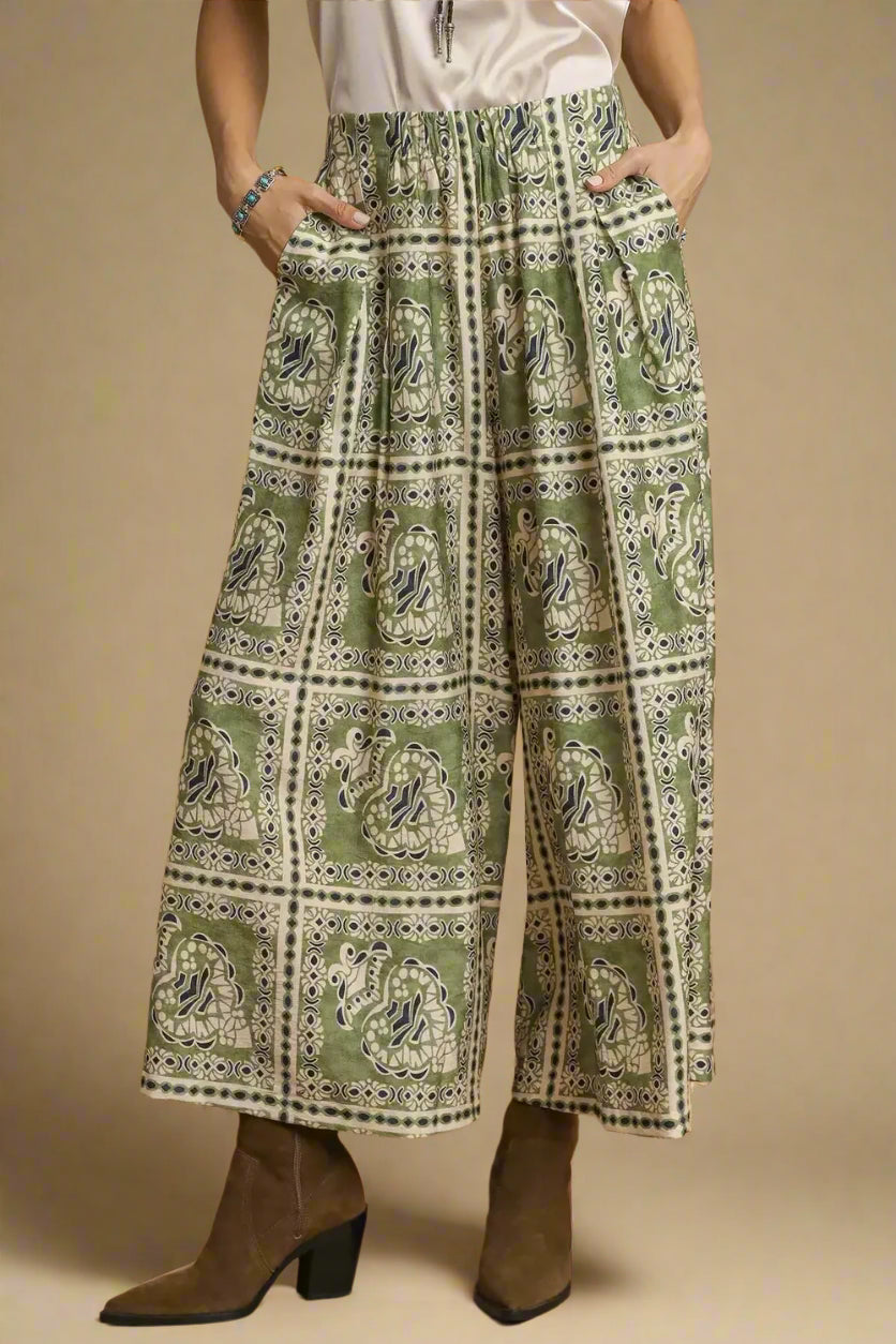 Person wearing green patterned pants with a brown background