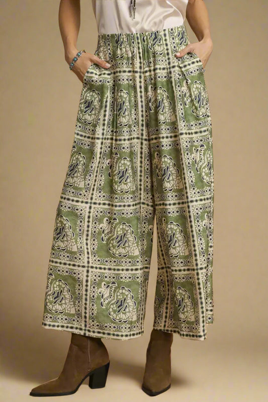 Person wearing green patterned pants with a brown background