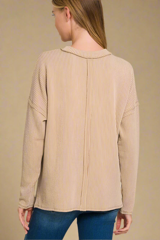 Light brown ribbed sweater worn by a person on a beige background
