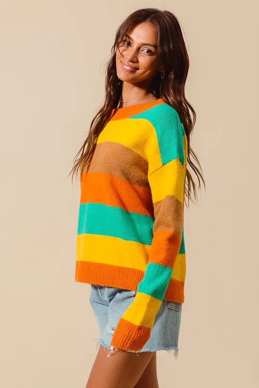 Woman wearing a colorful striped sweater against a beige background