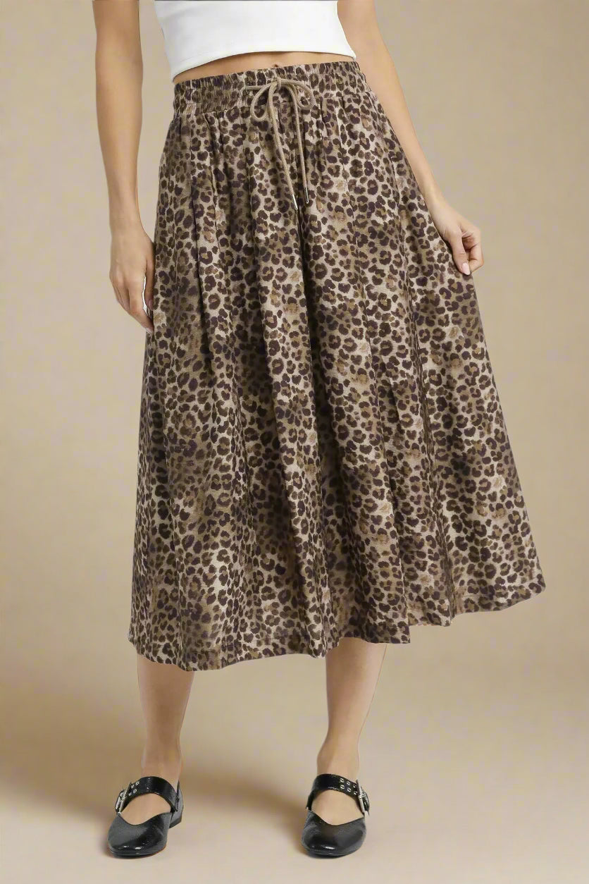 Person wearing a leopard print skirt on a white background