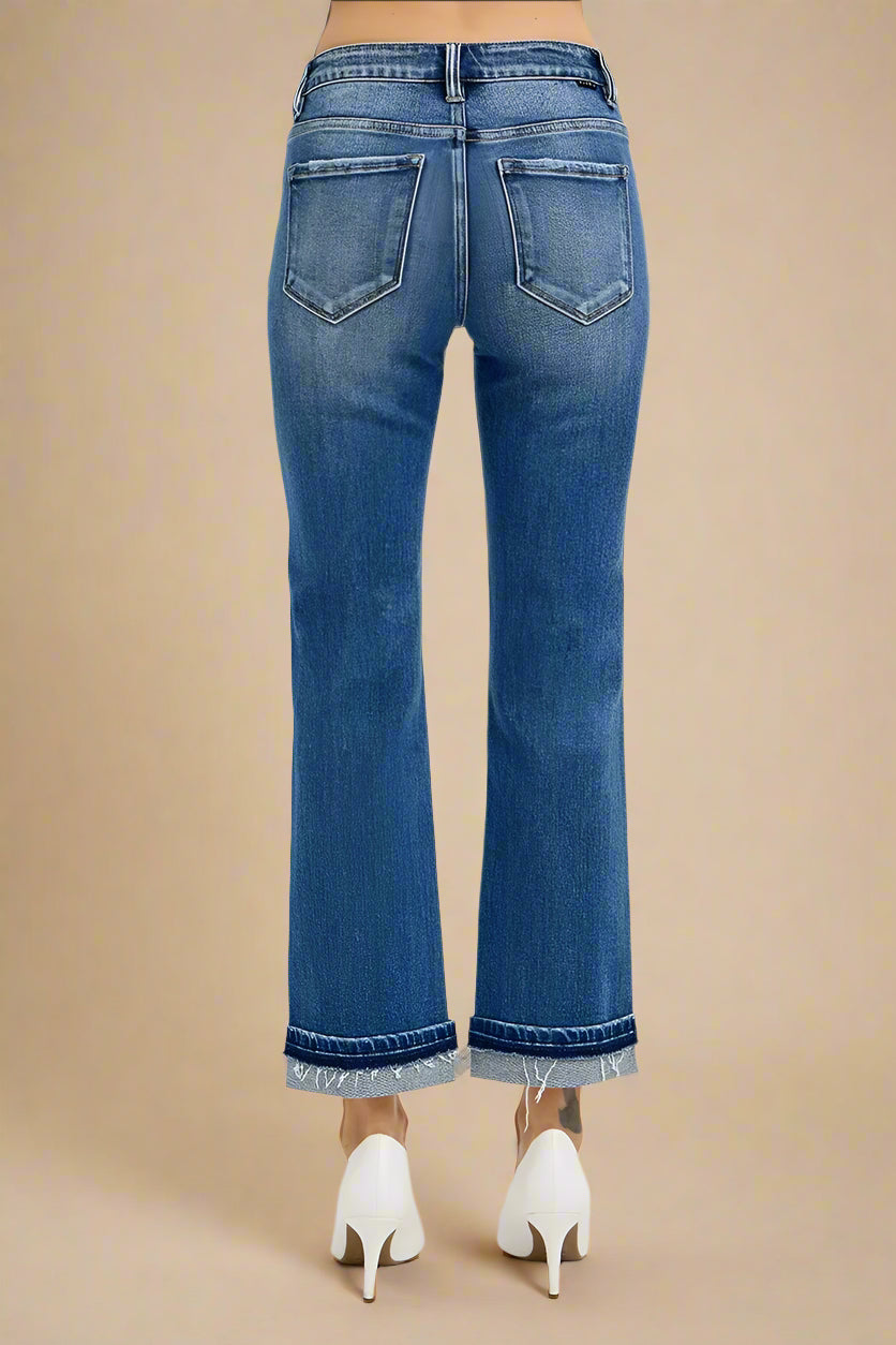Blue jeans worn by a person on a beige background