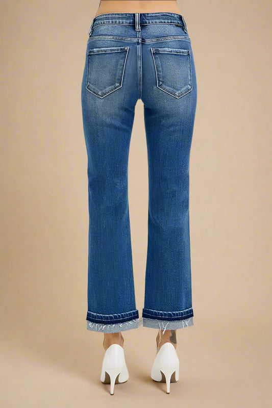 Blue jeans worn by a person on a beige background