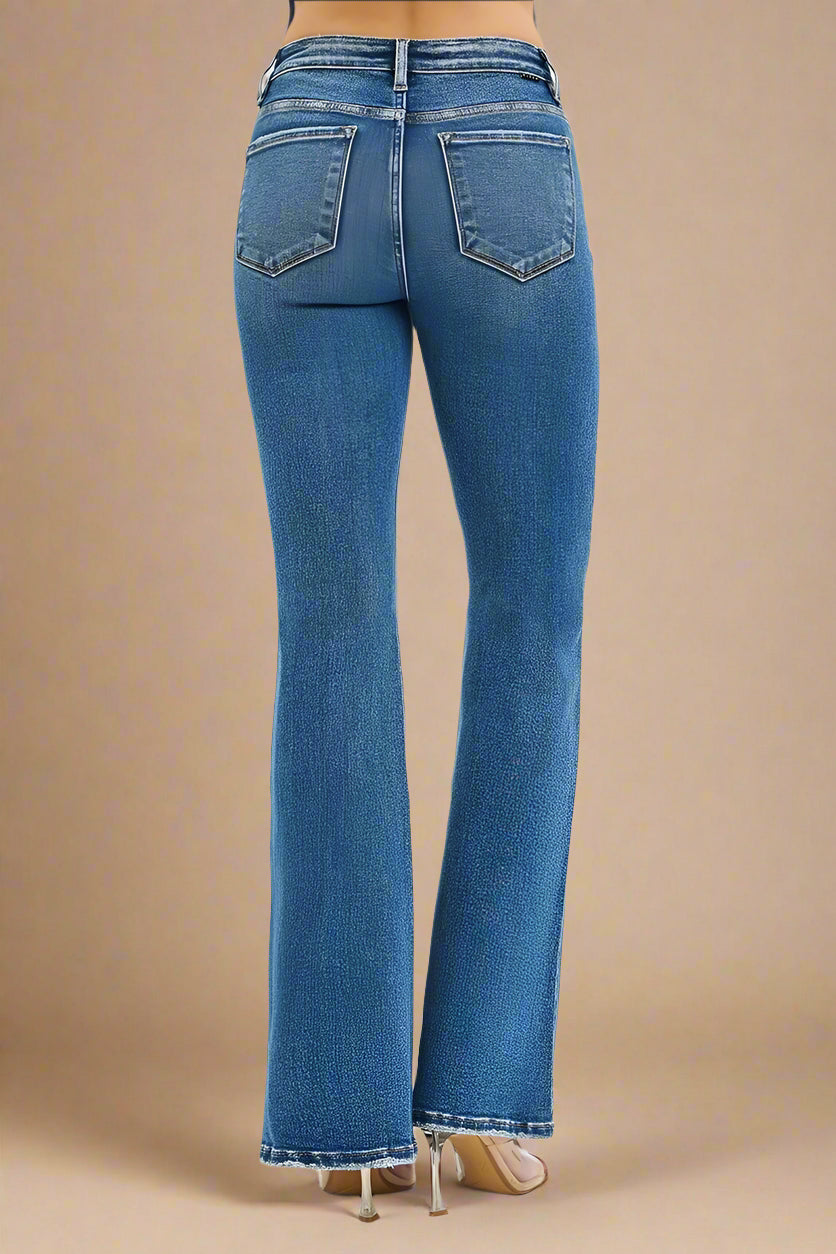 Blue jeans worn by a person on a beige background