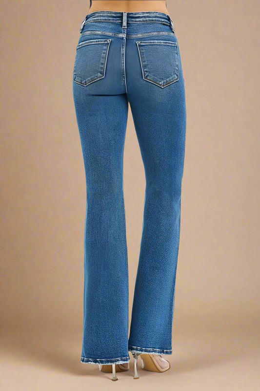 Blue jeans worn by a person on a beige background