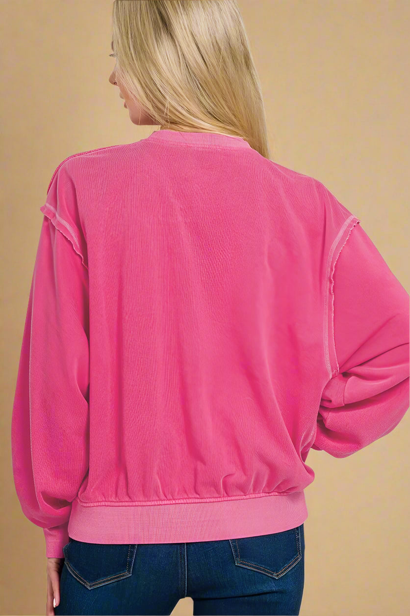 Pink sweatshirt worn by a person on a white background