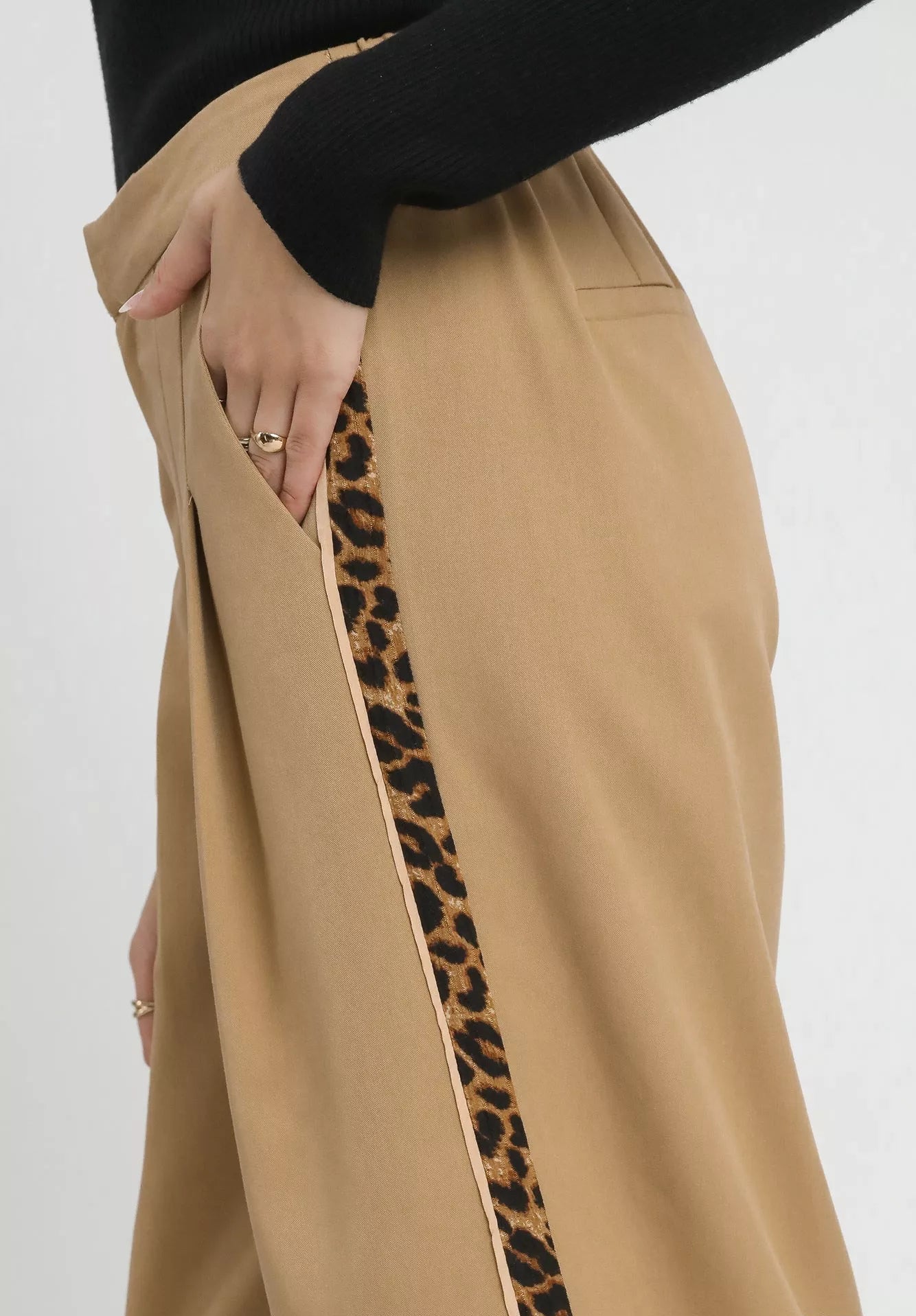 Tan pants with a leopard print side stripe on a white background