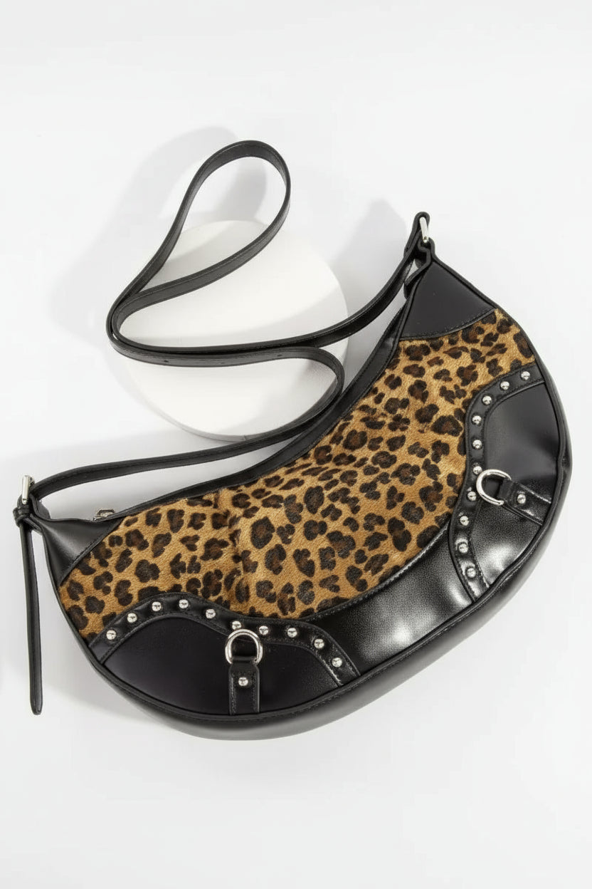 Leopard print handbag with black accents on a white background