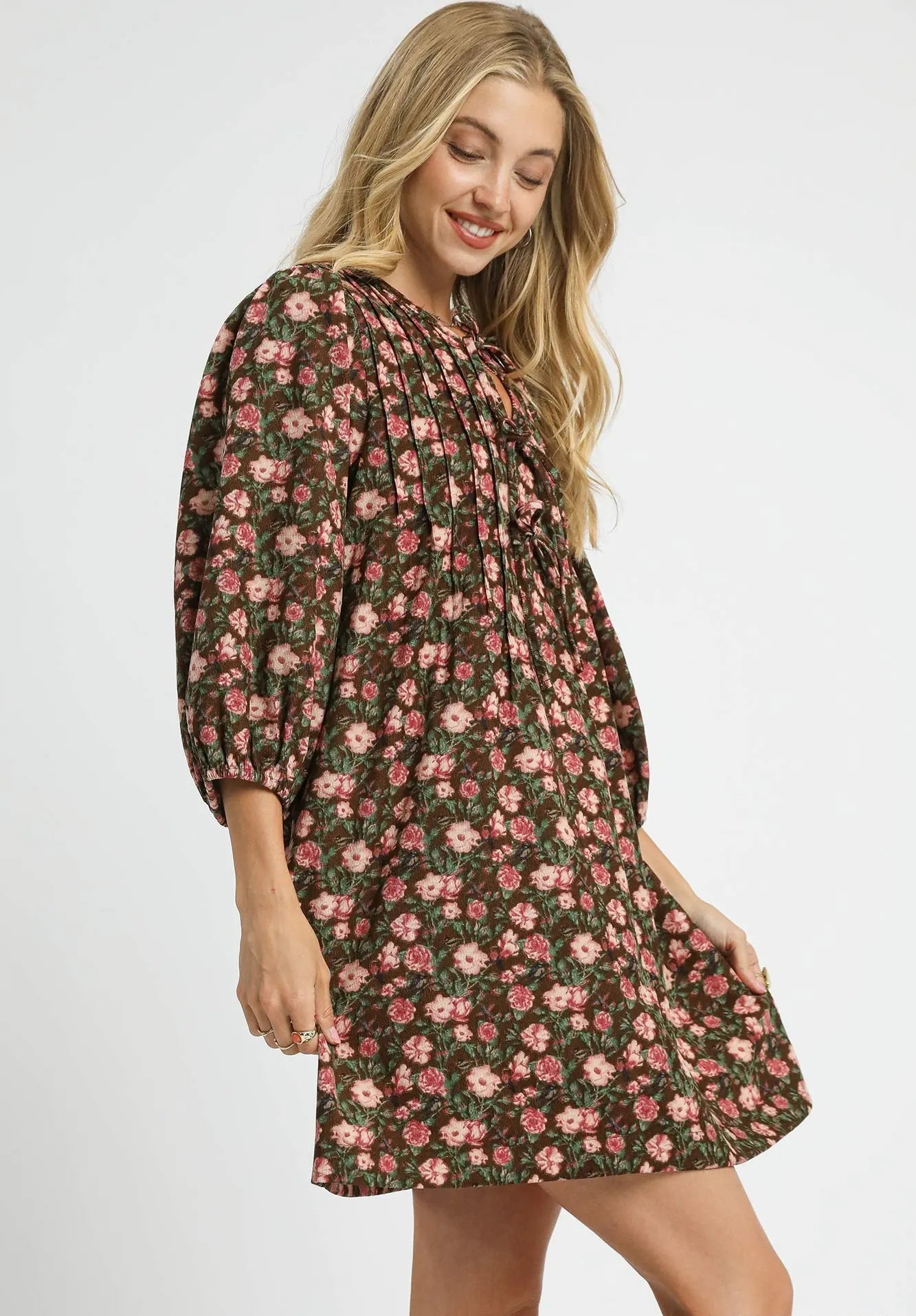 Woman wearing a floral dress with long sleeves on a white background