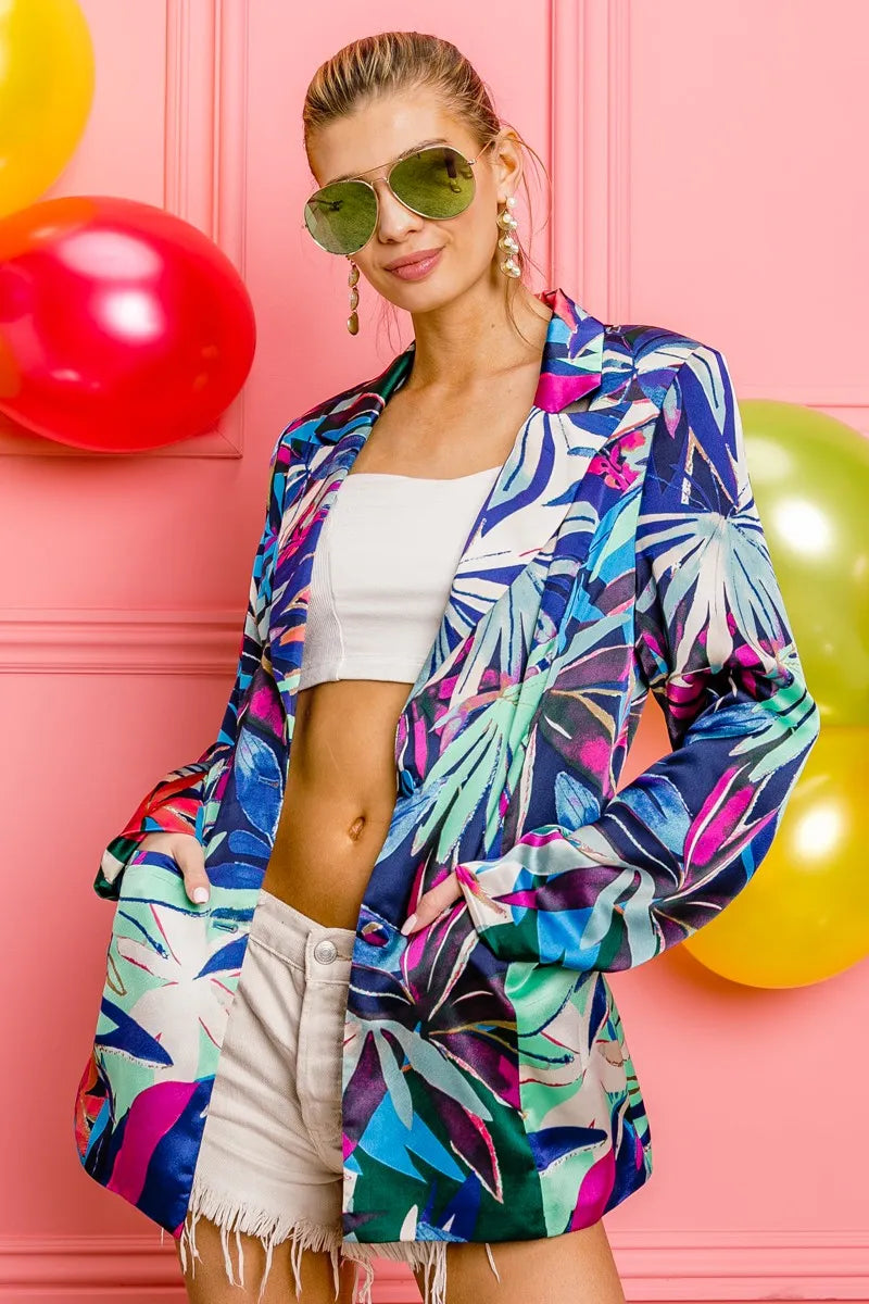 Woman wearing a colorful tropical print shirt with balloons in the background