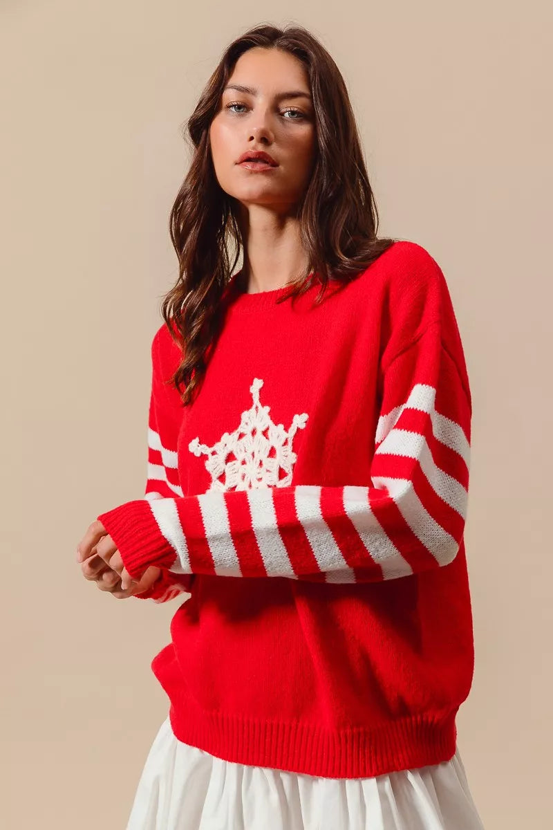 Woman wearing a red sweater with white snowflake design on a beige background