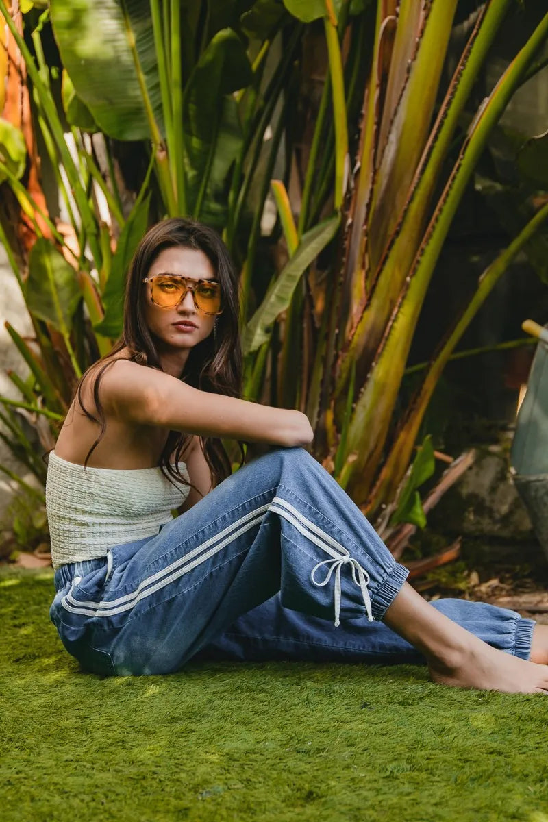 Woman sitting on grass with plants in the background
