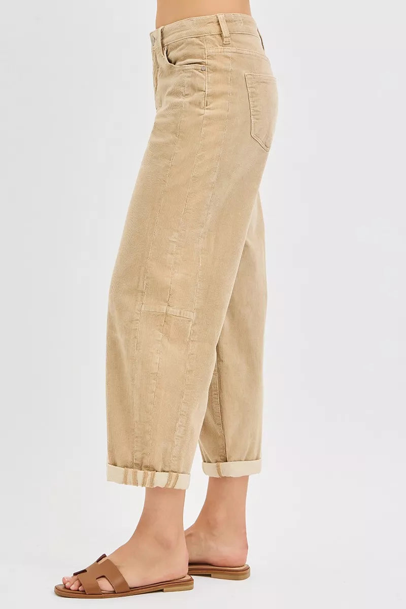 Beige corduroy pants worn by a person on a white background
