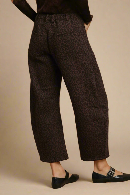 Brown patterned pants worn by a person on a beige background