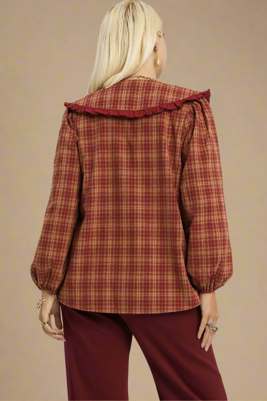 Plaid shirt with ruffled collar and burgundy pants on a plain background