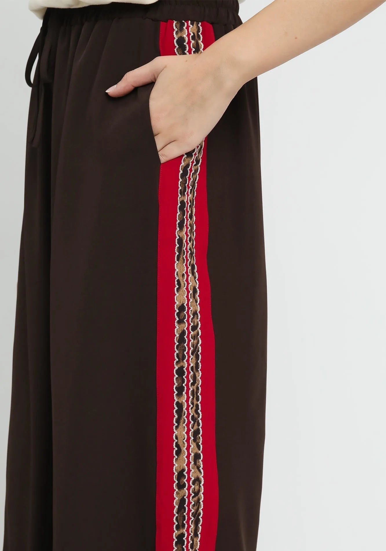 Brown skirt with a red and patterned side stripe on a white background