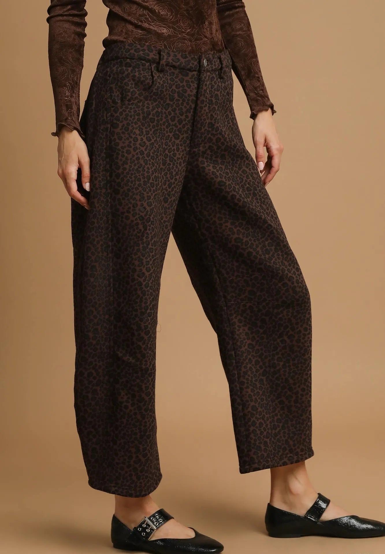 Brown patterned pants worn by a person on a beige background