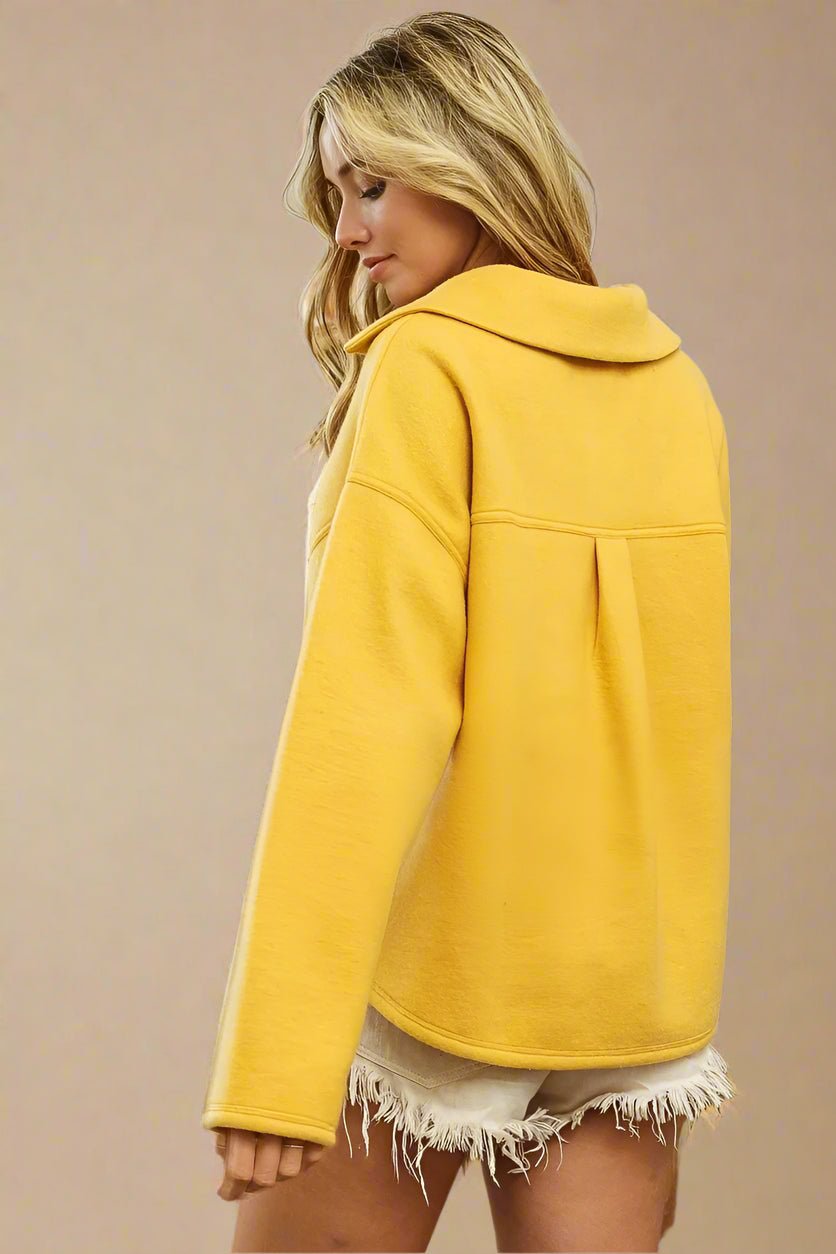 Woman wearing a yellow coat on a beige background