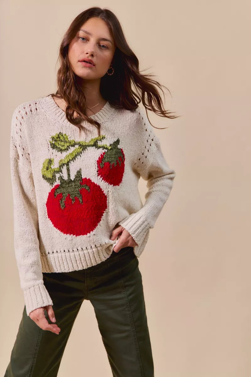 Woman wearing a sweater with tomato design on a beige background