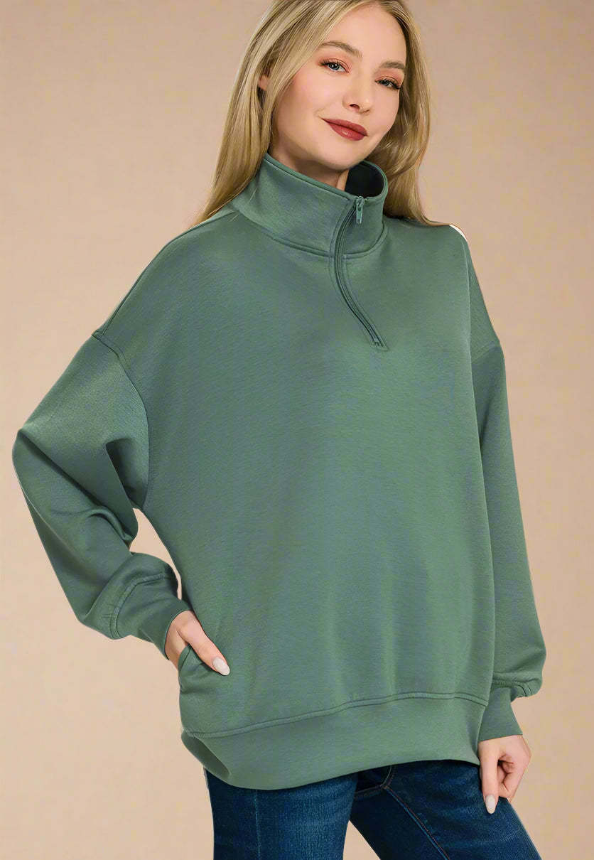 Woman wearing a green sweatshirt with a plain background