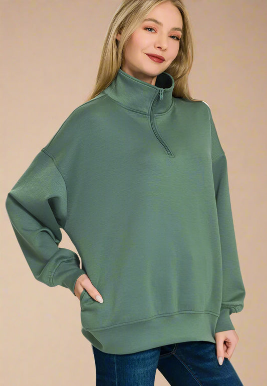 Woman wearing a green sweatshirt with a plain background