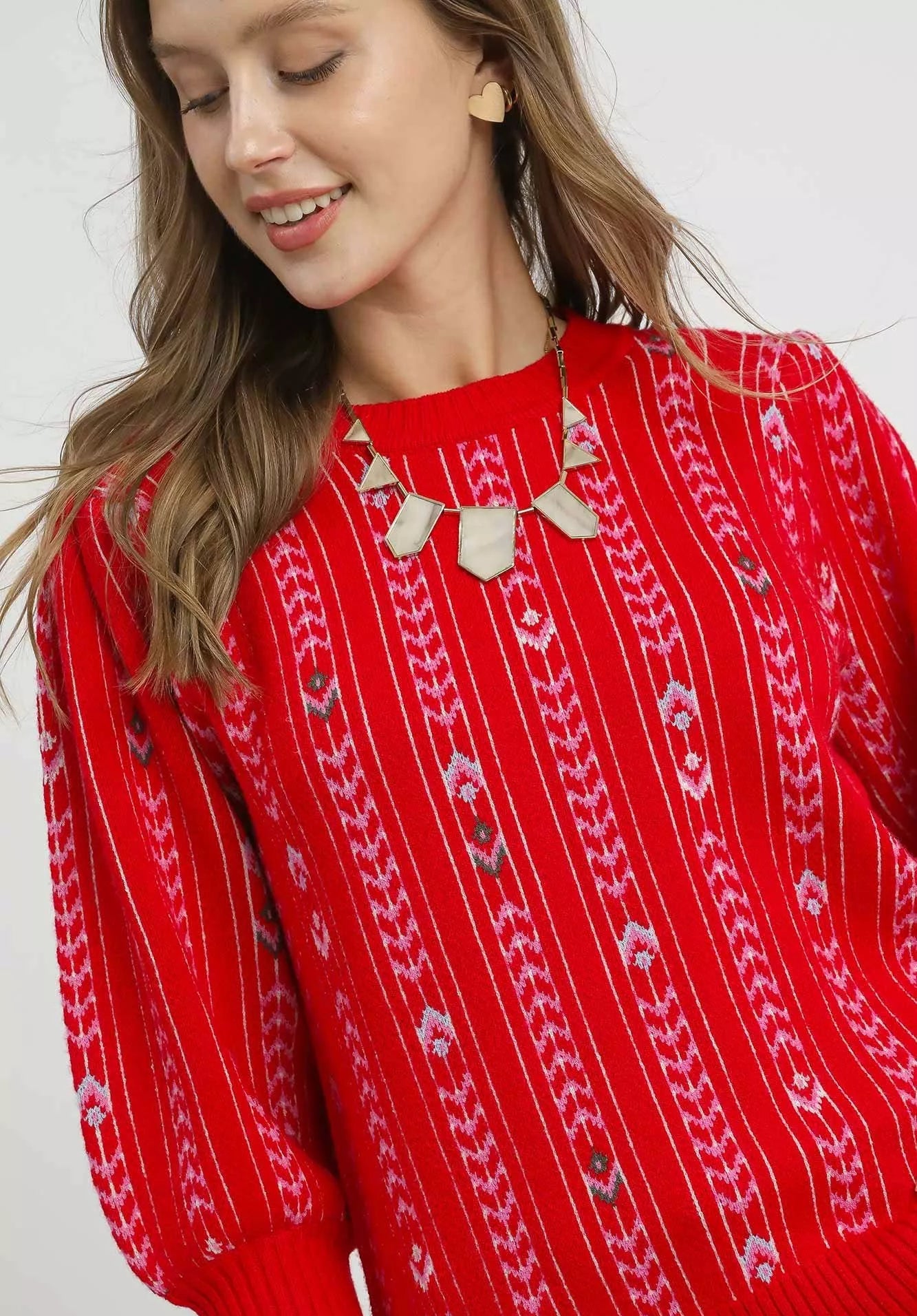 Person wearing a red sweater with white patterns on a white background