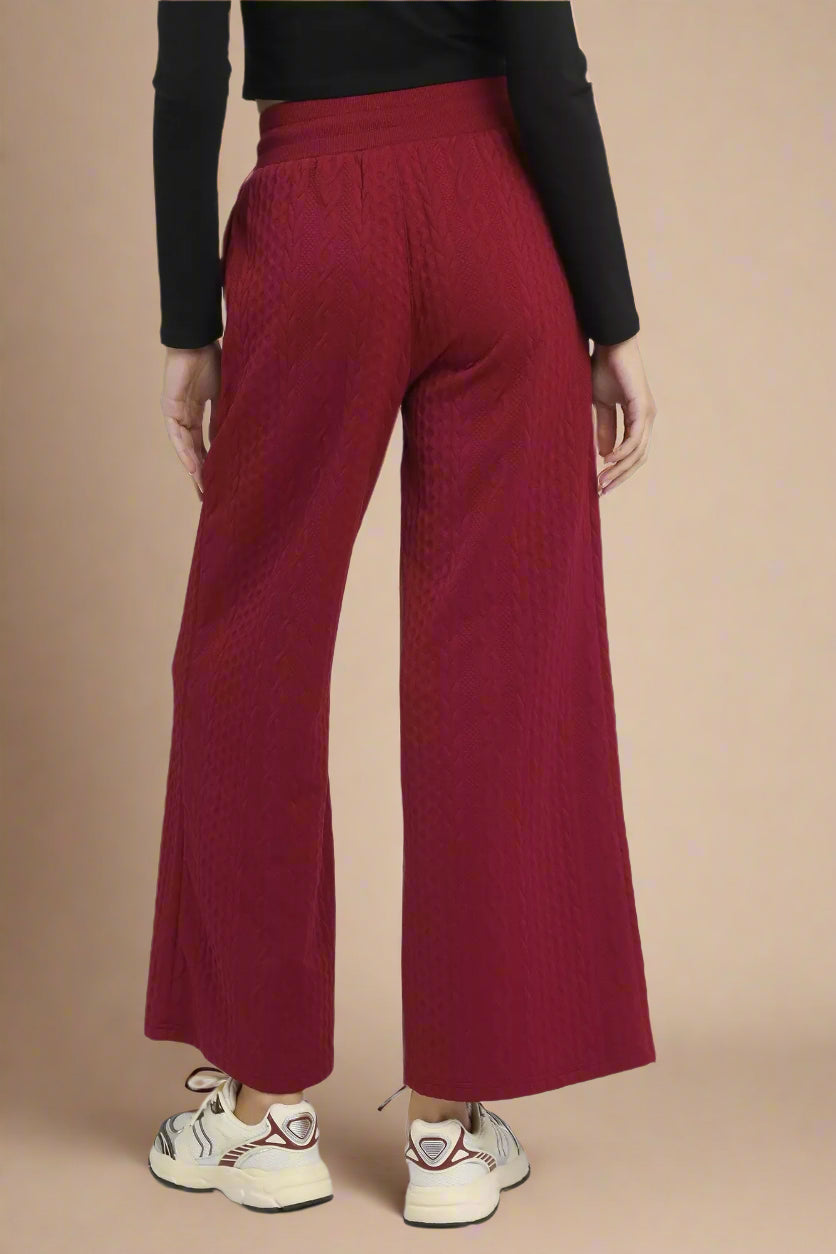 Burgundy wide-leg pants worn by a person on a white background