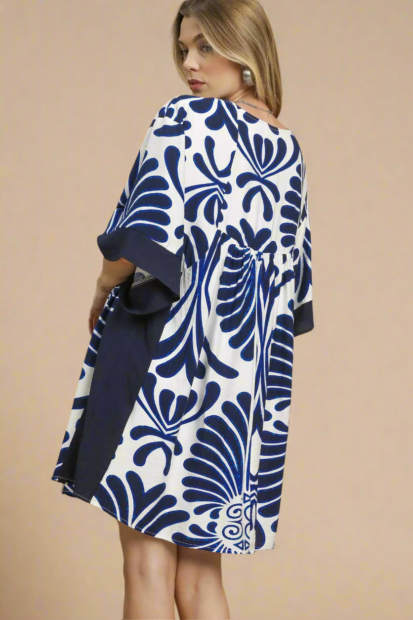 Woman wearing a blue and white patterned dress on a beige background