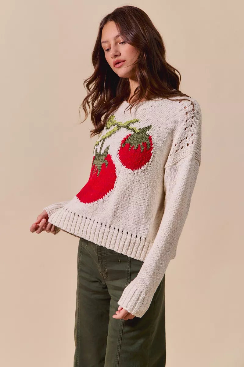 Woman wearing a sweater with tomato design on a beige background