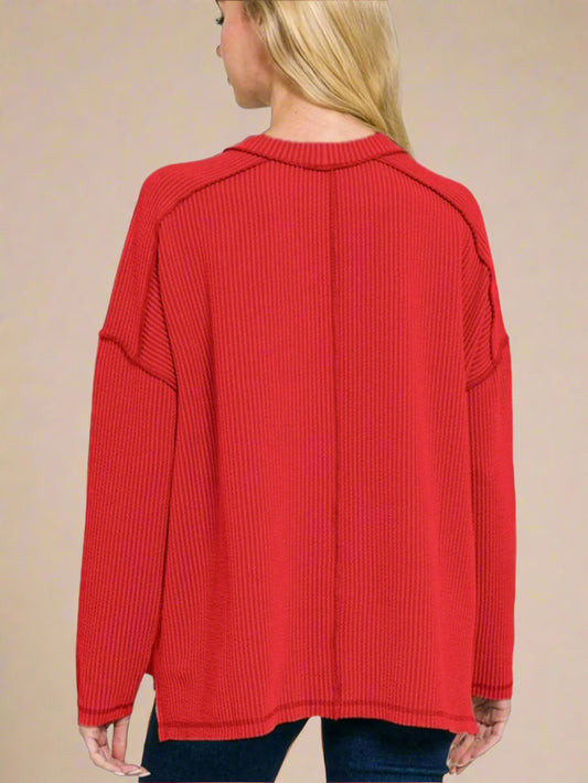 Red ribbed sweater worn by a person on a white background
