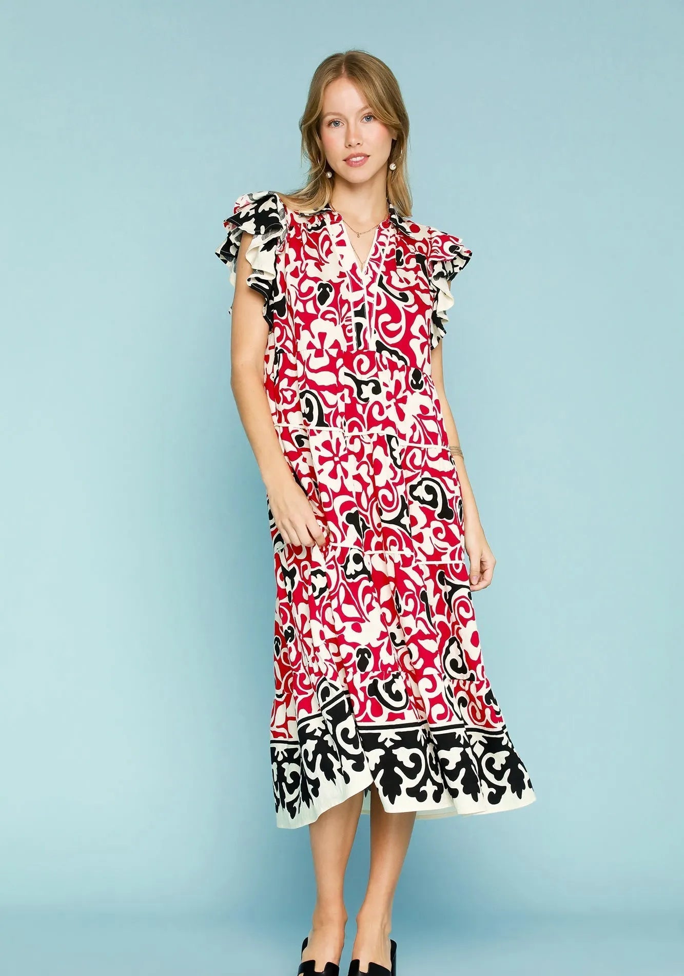 Woman wearing a red and black patterned dress on a light blue background