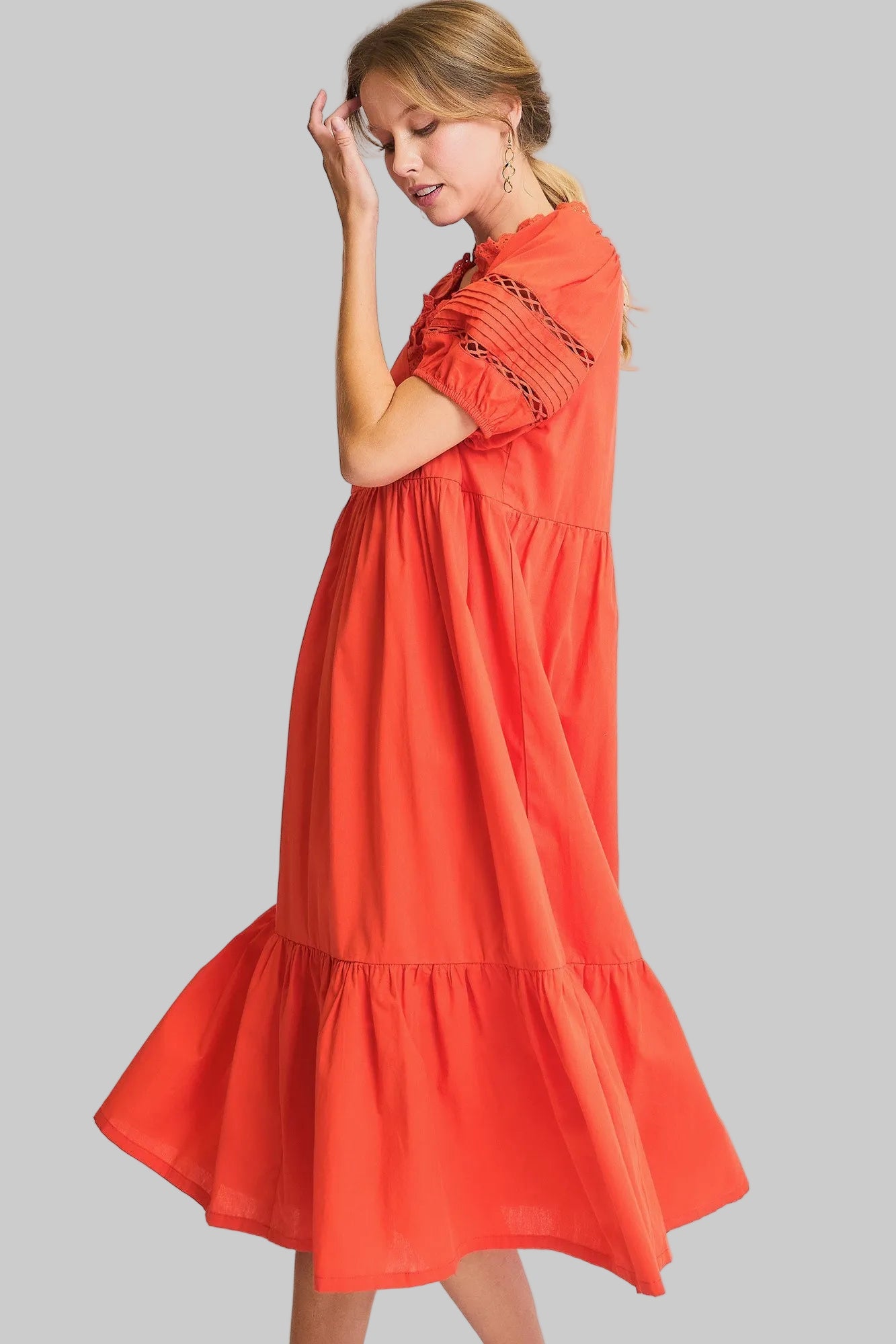 Woman wearing a red dress with embroidery on a light gray background