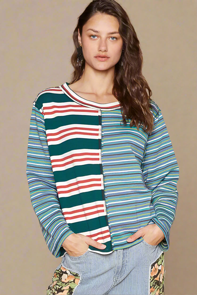 Woman wearing a colorful striped shirt against a beige background