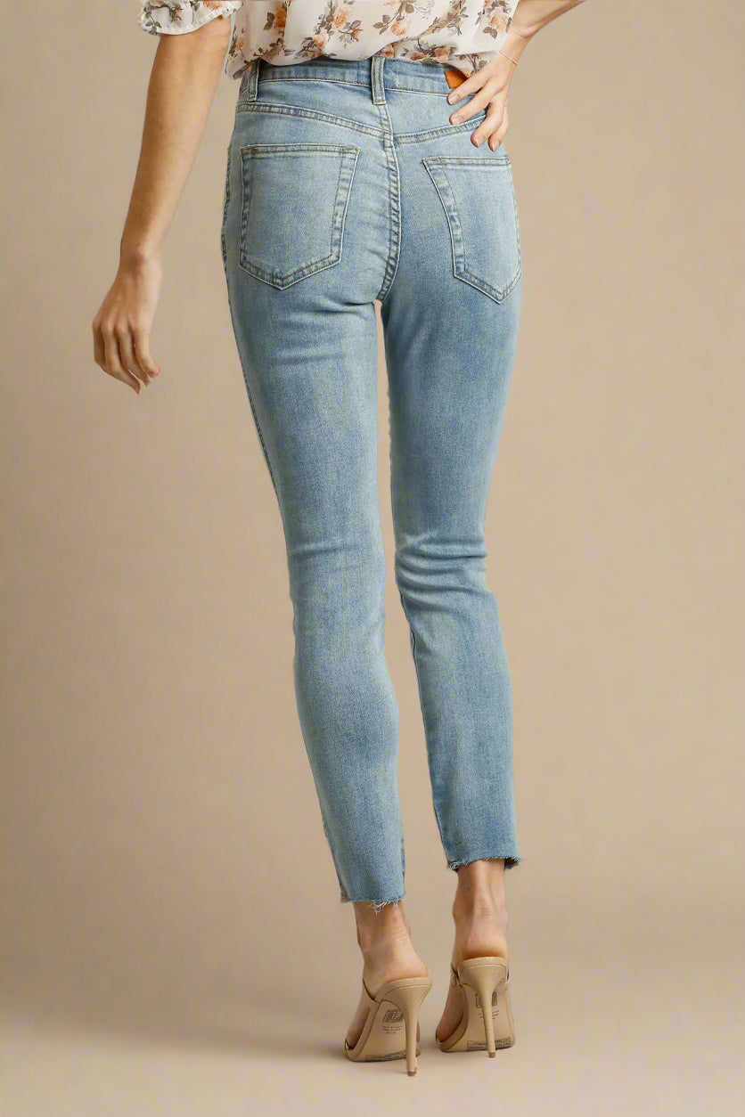 Light blue jeans worn by a person on a beige background
