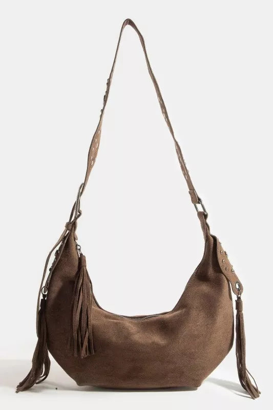 Brown leather handbag with tassels on a white background