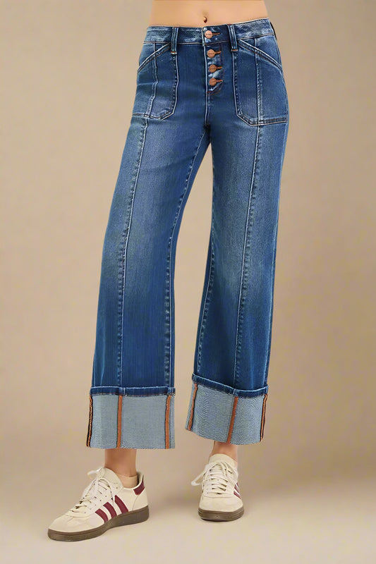 Blue jeans with a button fly worn by a person on a white background