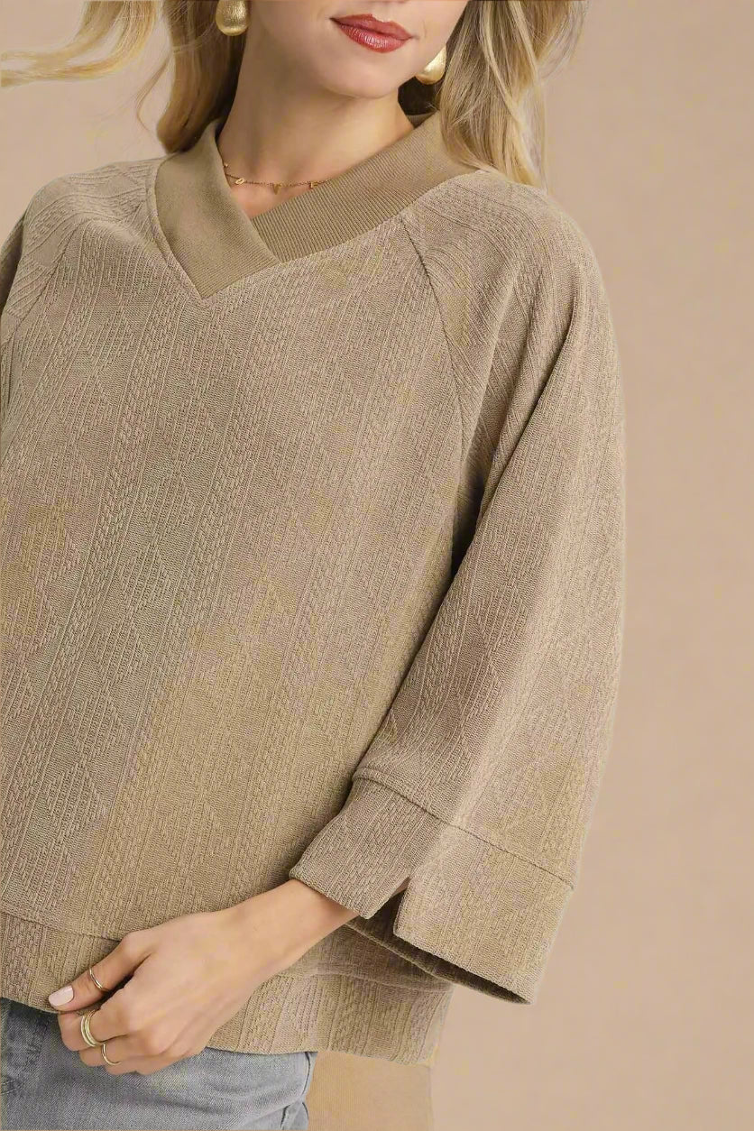 Beige sweater worn by a person on a white background