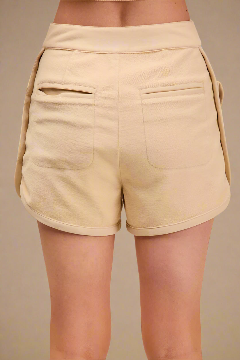Beige shorts worn by a person on a beige background