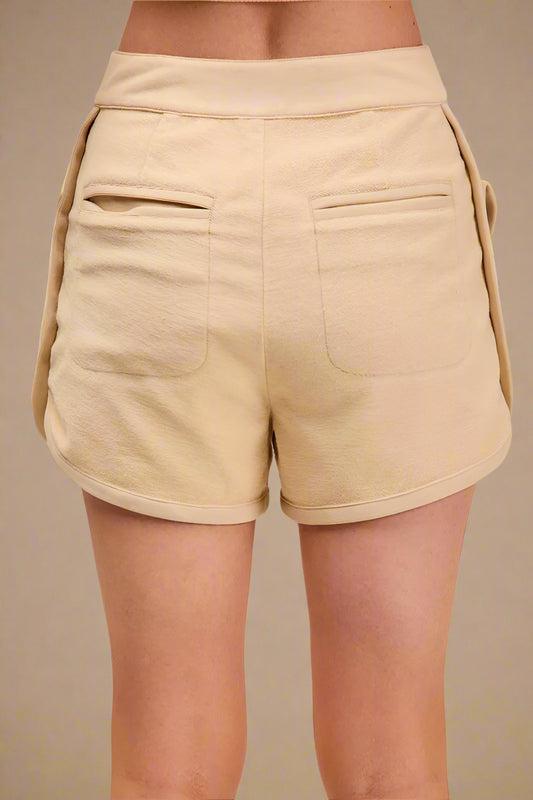 Beige shorts worn by a person on a beige background
