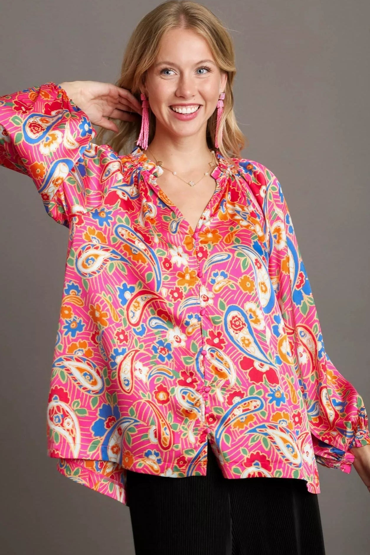 Woman wearing a colorful paisley blouse with a gray background