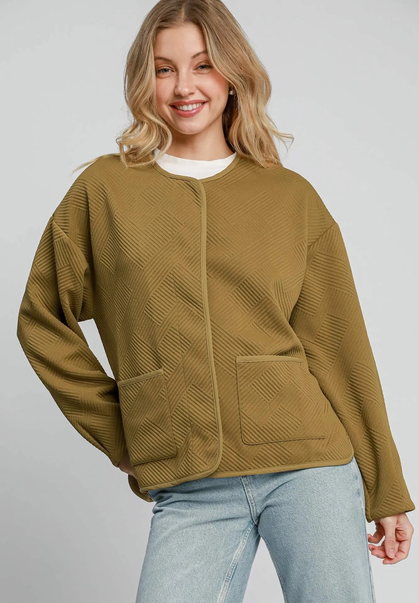 Woman wearing a green jacket with a plain background