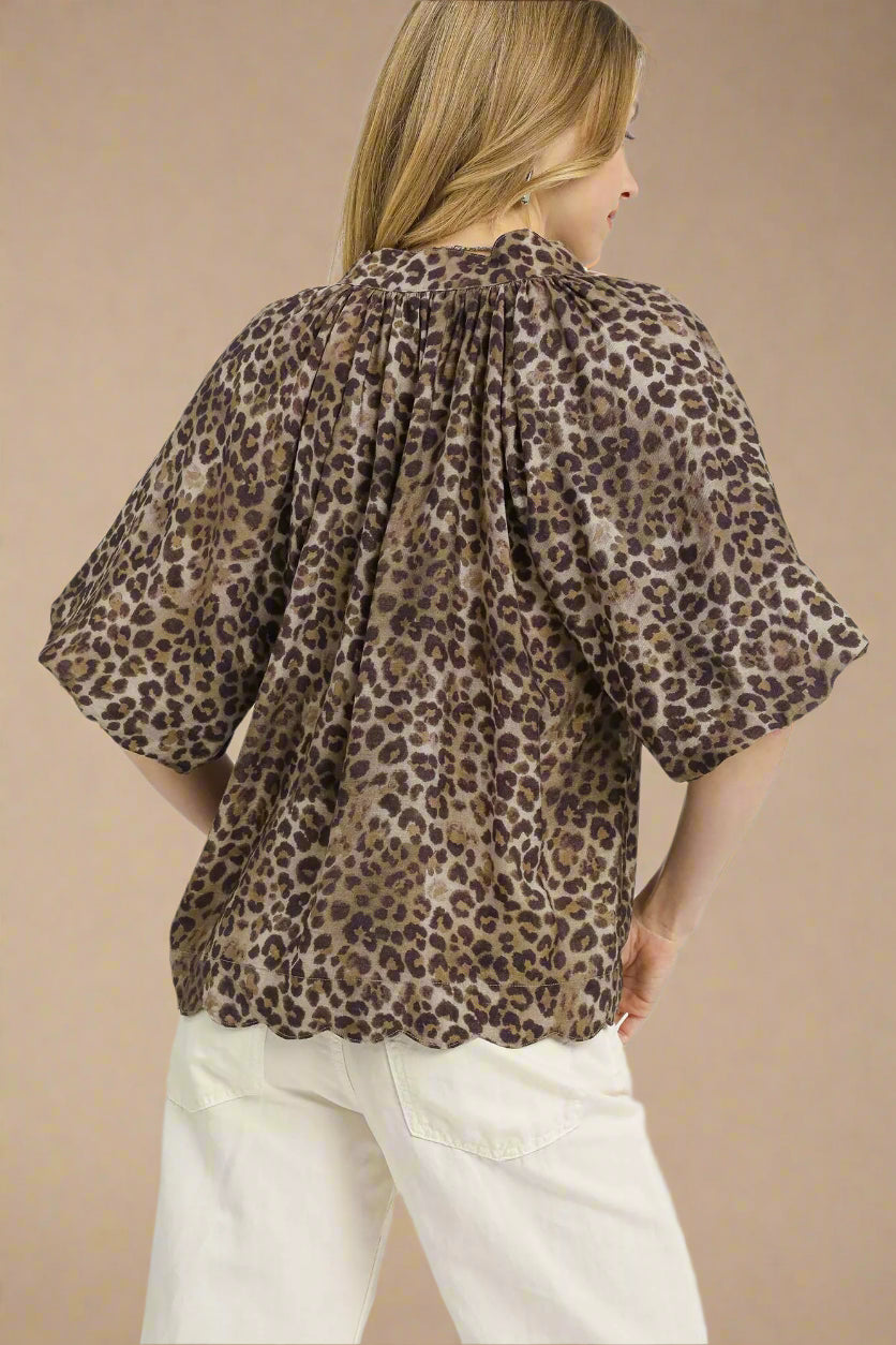 Woman wearing a leopard print blouse with a plain background