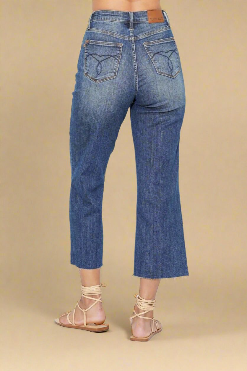 Blue jeans worn by a person on a beige background