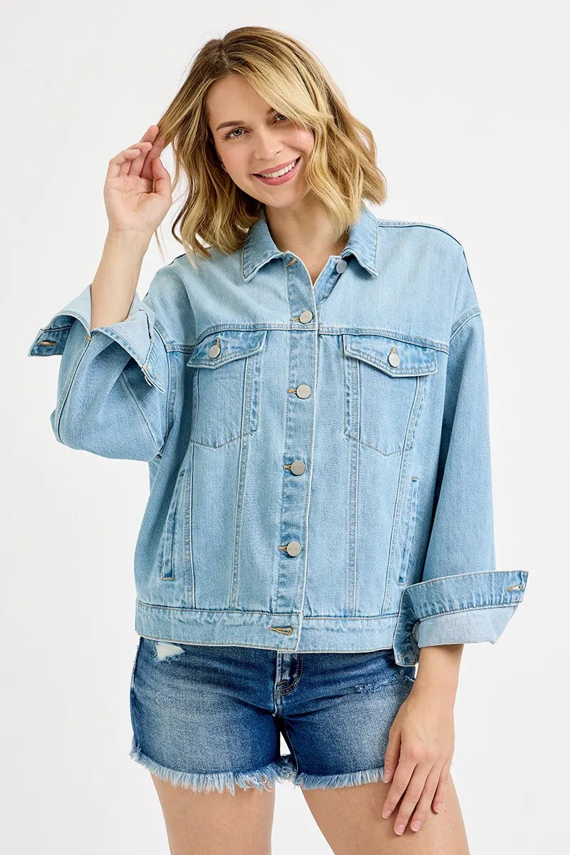 Woman wearing a light blue denim jacket and shorts on a white background