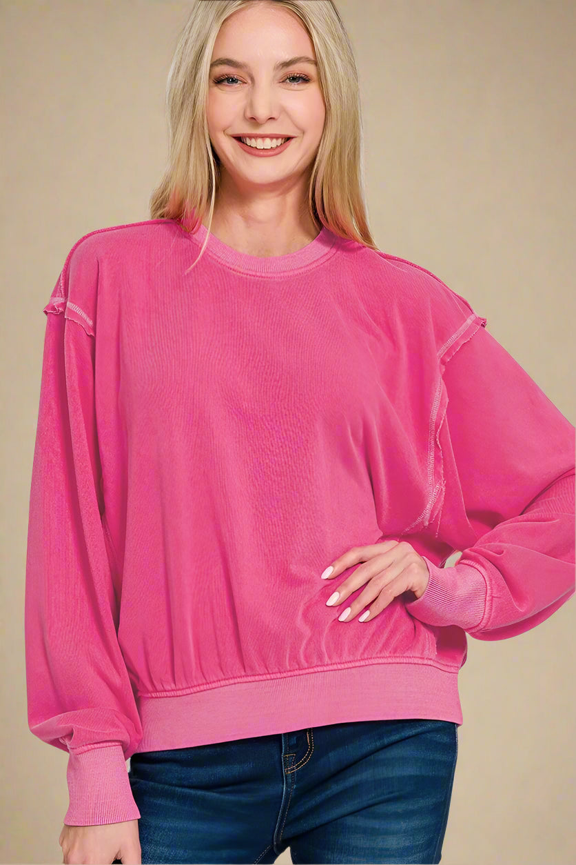 Woman wearing a hot pink sweatshirt on a white background