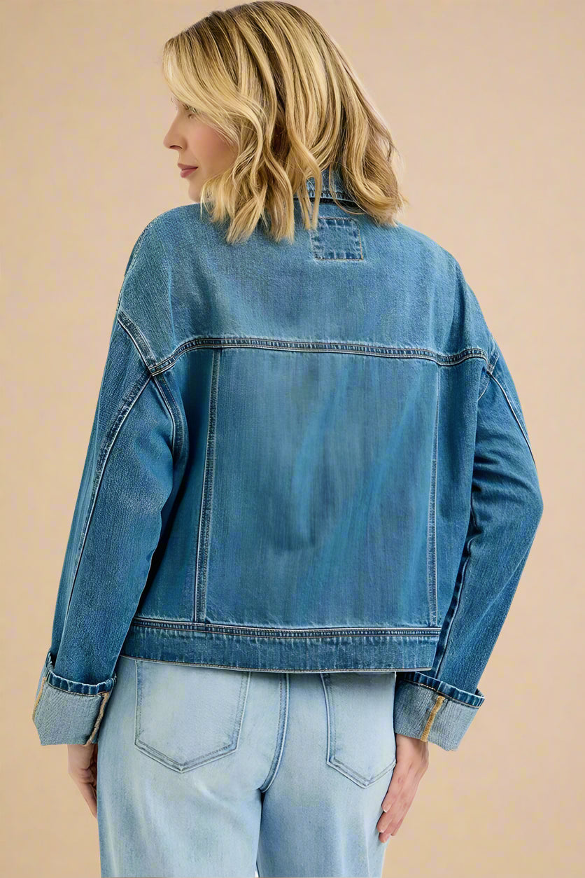Person wearing a blue denim jacket on a white background
