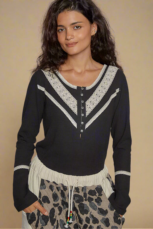 Woman wearing a black and white patterned top with leopard print pants against a beige background