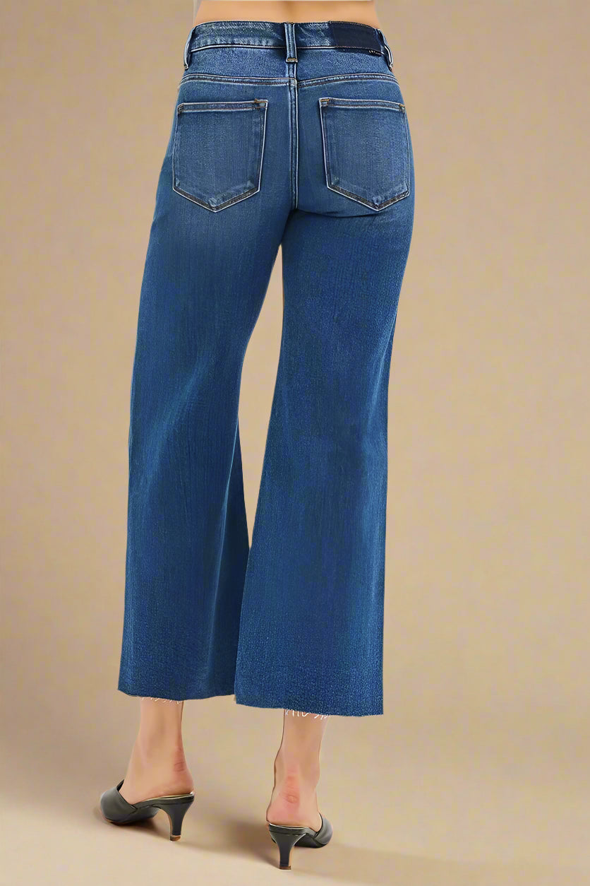 Blue jeans worn by a person on a beige background