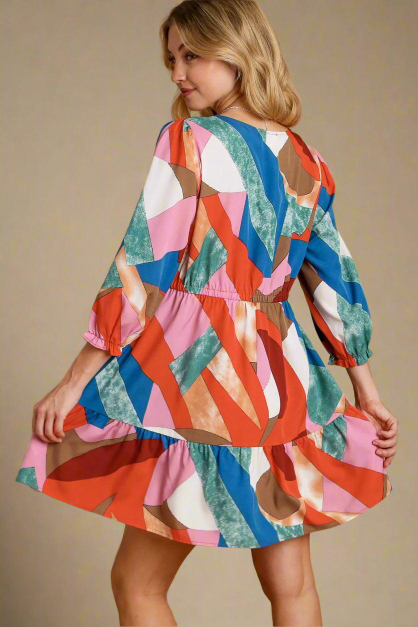 Woman wearing a colorful patterned dress on a beige background