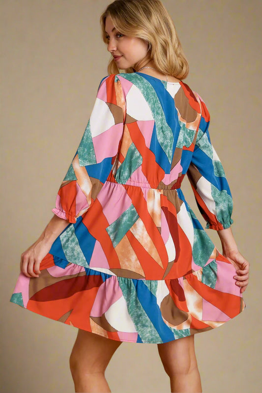 Woman wearing a colorful patterned dress on a beige background